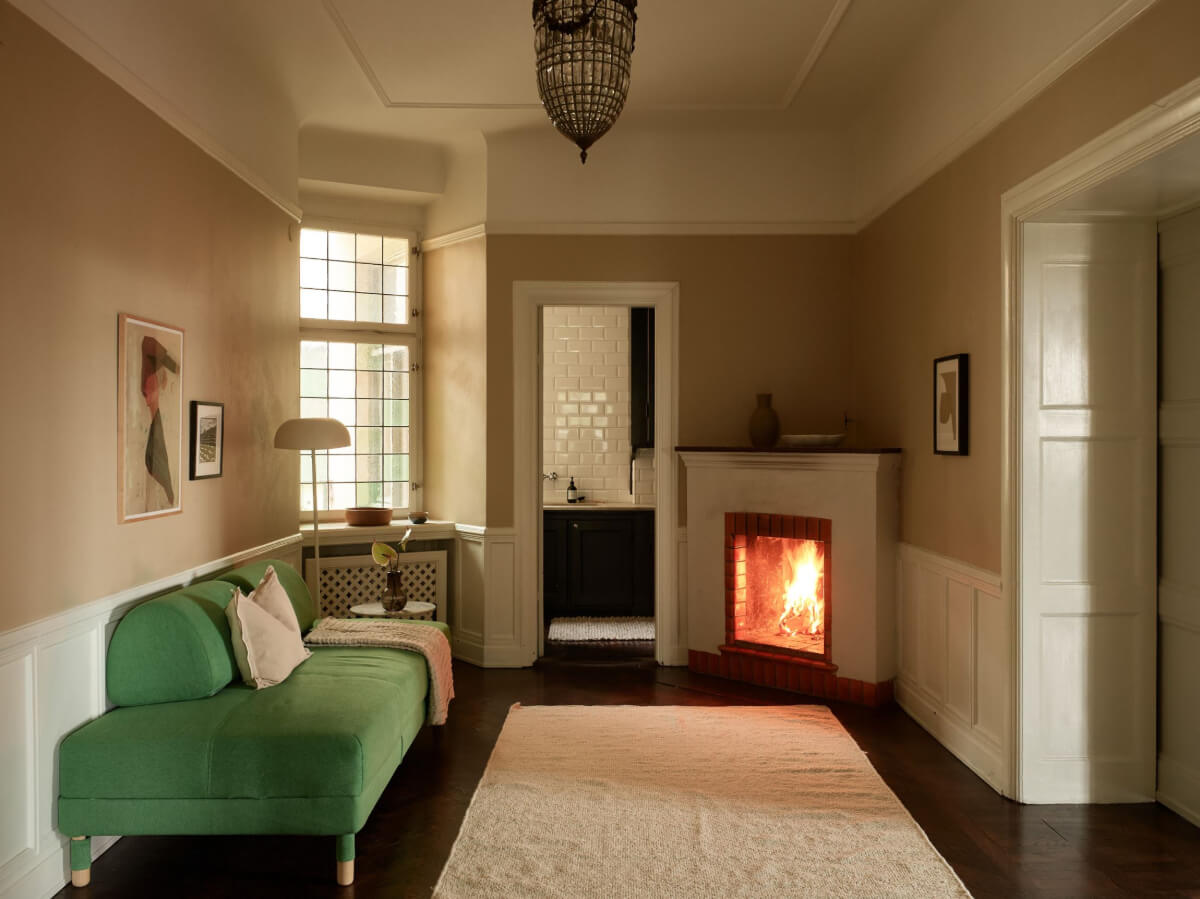 A Grand Early 20th-Century Apartment in Stockholm 13 sitting room green sofa fireplace