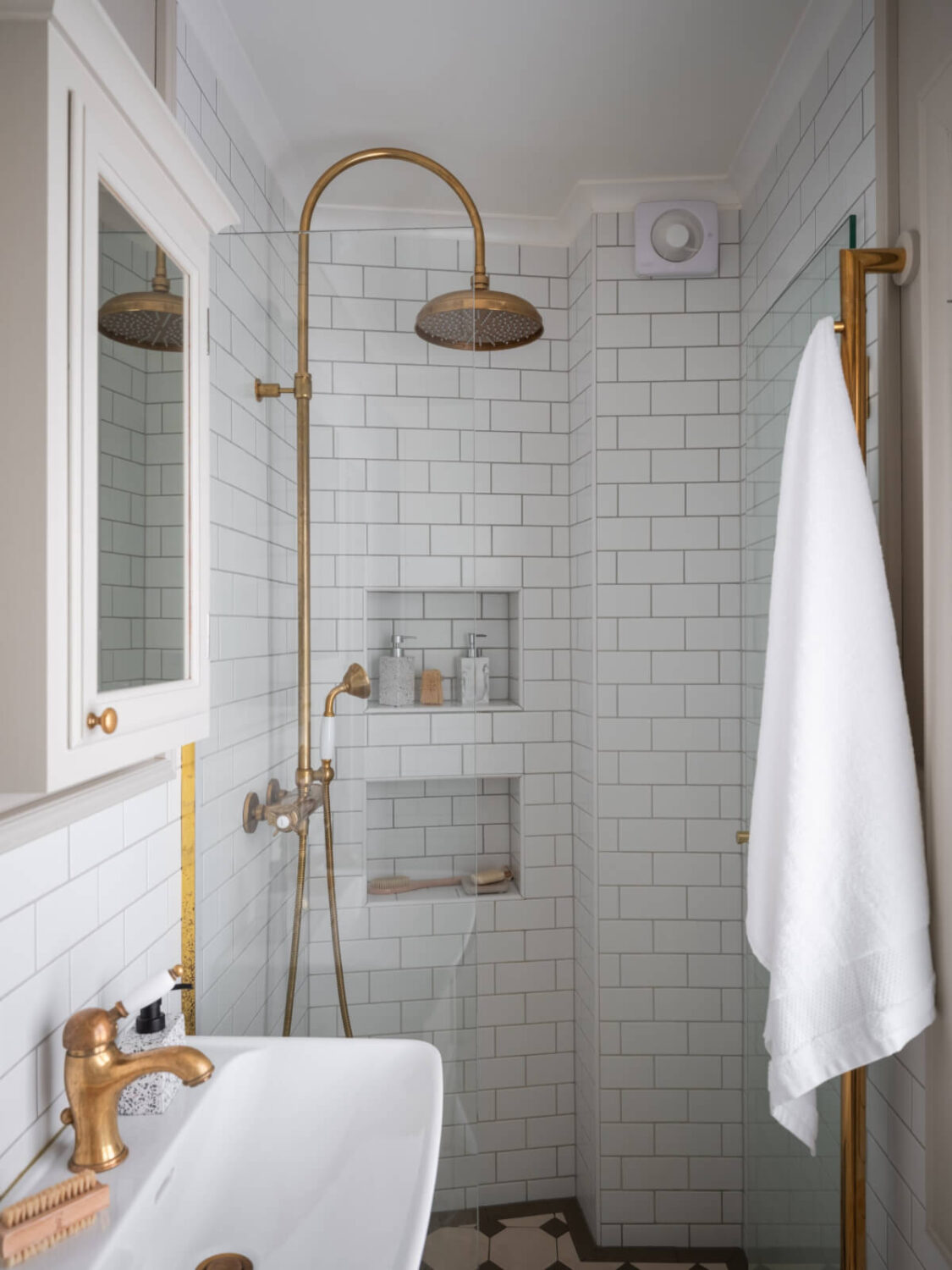 A Carefully Renovated Family Home in Sweden 32 small bathroom with white tiles and brass fittings