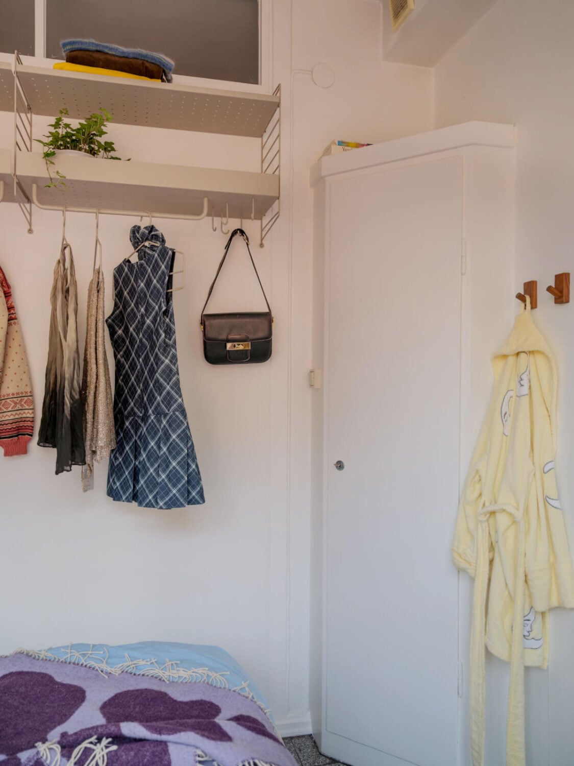 An Airy One-Bedroom Apartment with Art and A Yellow Kitchen 9 small corner built-in wardrobe