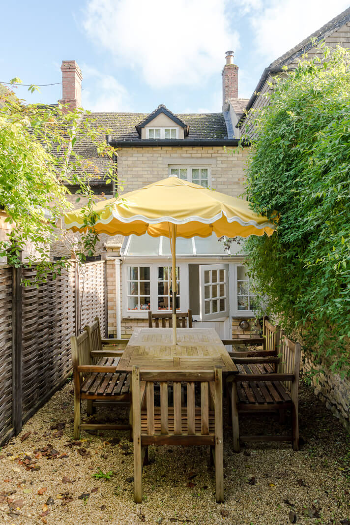 A Carefully Selected Color Palette in an 18th-Century English Cottage 18 small garden with dining table and yellow parasol