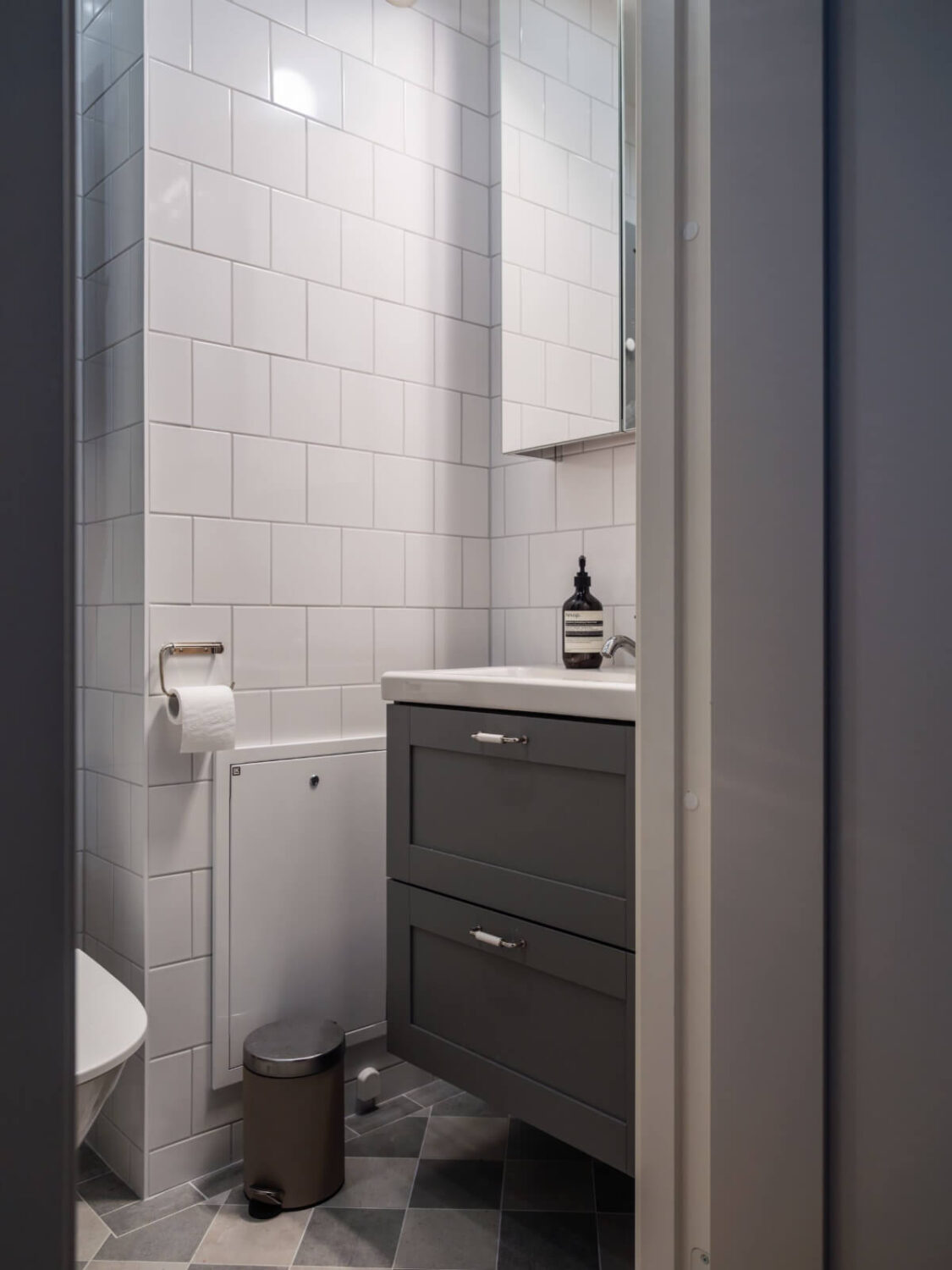A Studio Apartment with Smart Storage Ideas and Exposed Brick 14 small gray and white bathroom