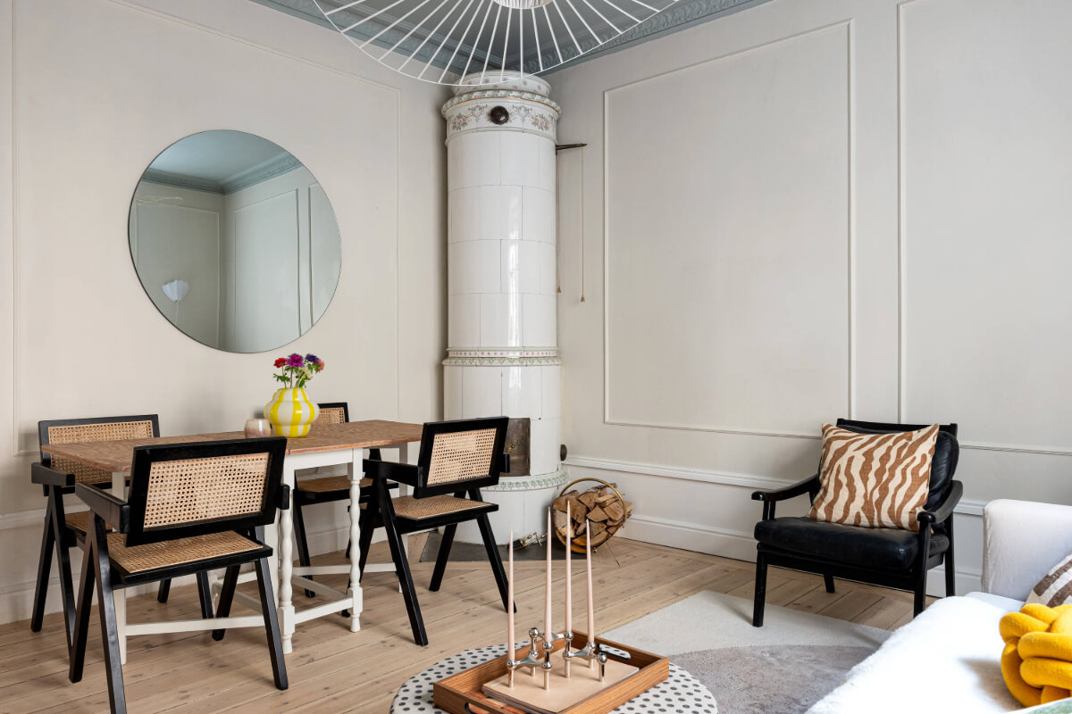 An Elegant Stockholm Apartment with a Pink and Black Kitchen 3 small living room wooden floor dining table round mirror