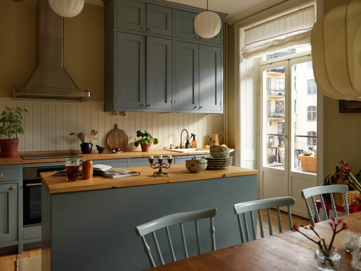 A Charming Historic Stockholm Apartment with a Blue Kitchen 9 soft blue kitchen cabinets wooden countertop