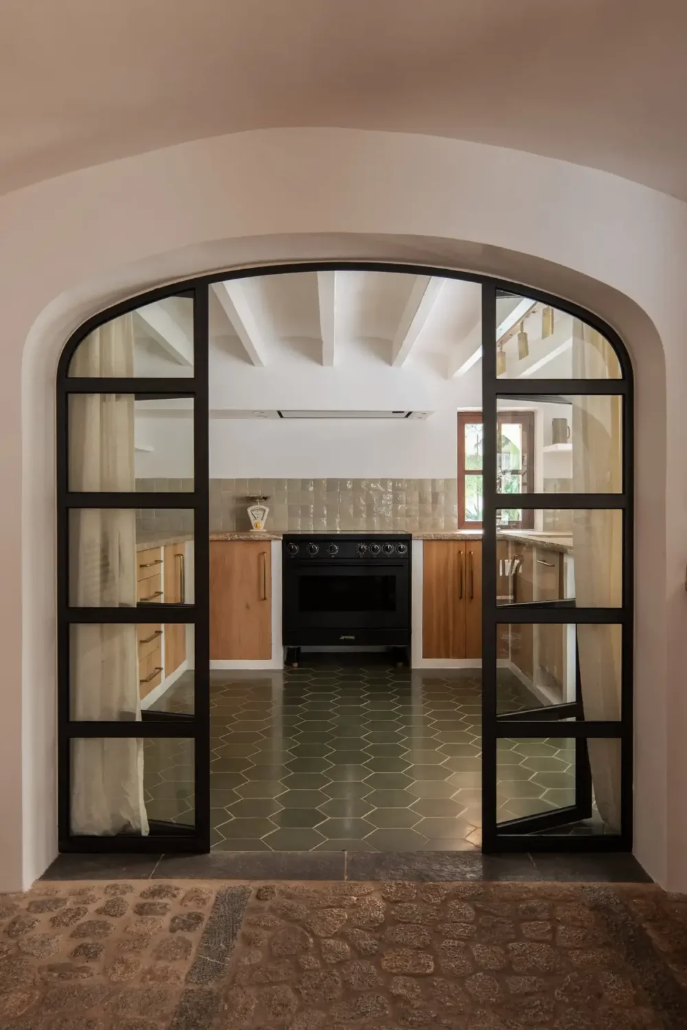 Old-World Craftsmanship and Contemporary Elegance in a Mallorcan Townhouse 3 steel framed glass doors to kitchen