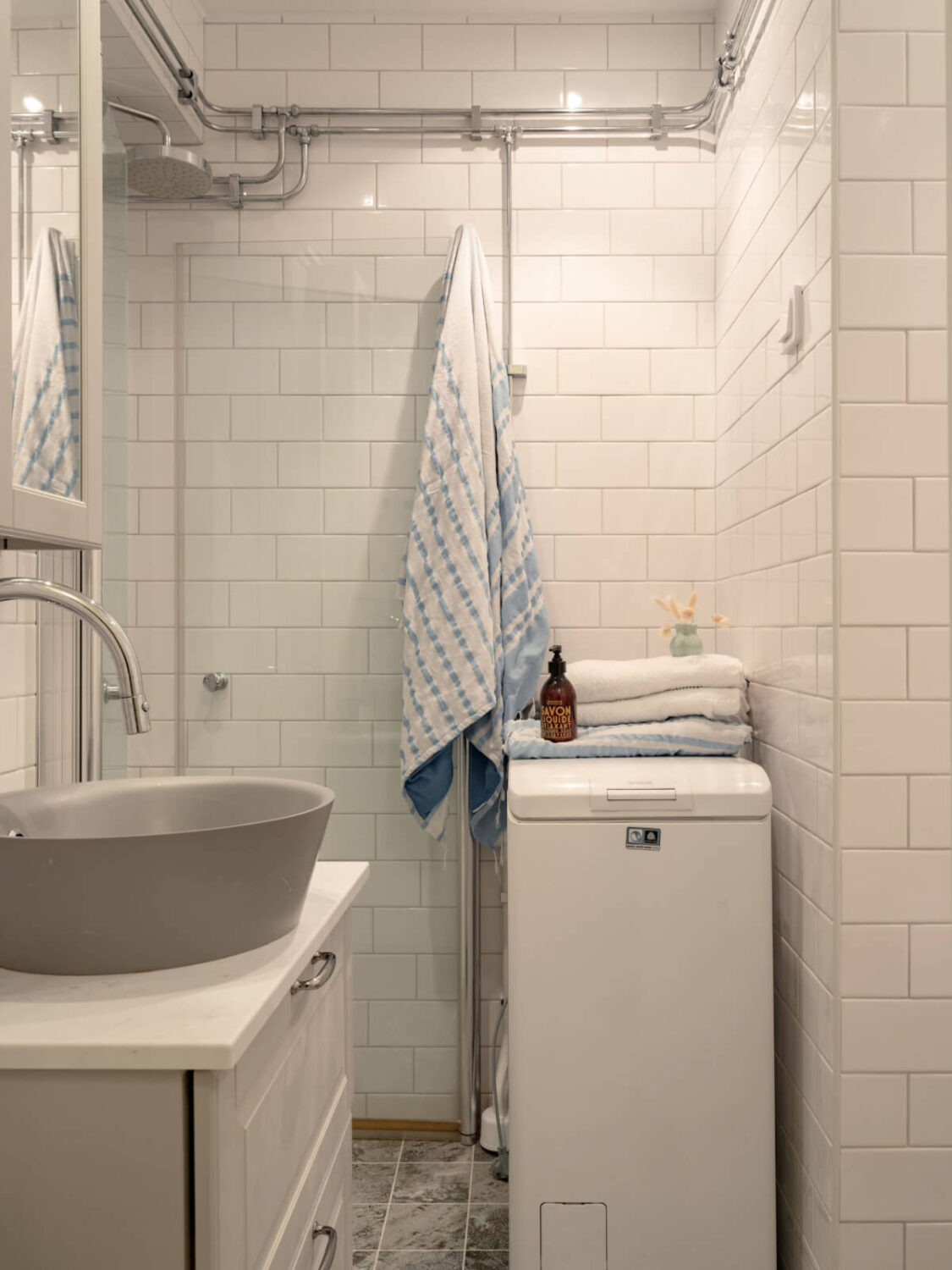 A Small Apartment with High Ceilings and a Large Bay Window 22 tiny bathroom white tiles gray sink