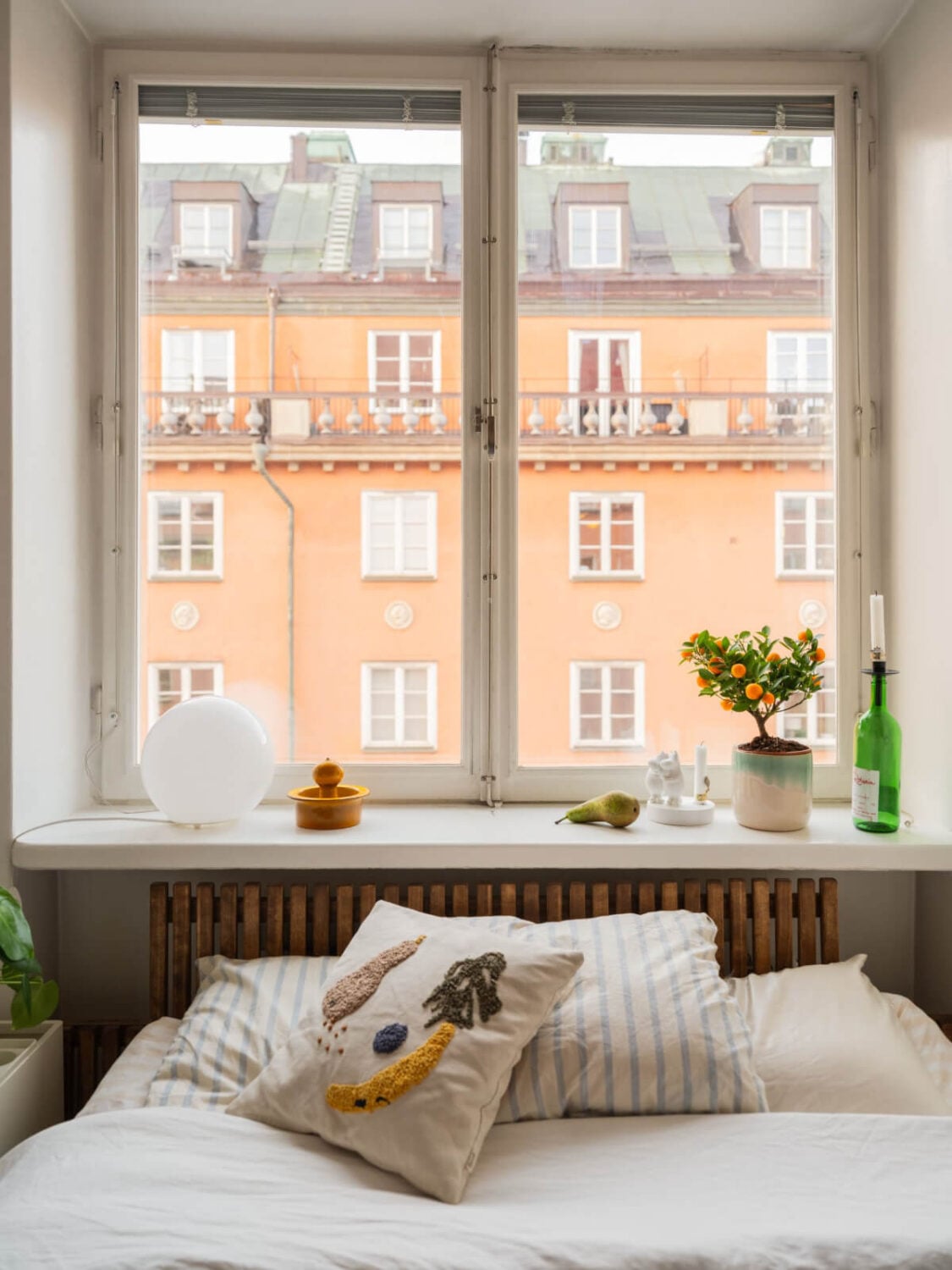An Airy One-Bedroom Apartment with Art and A Yellow Kitchen 8 tiny bedroom window sill nightstand