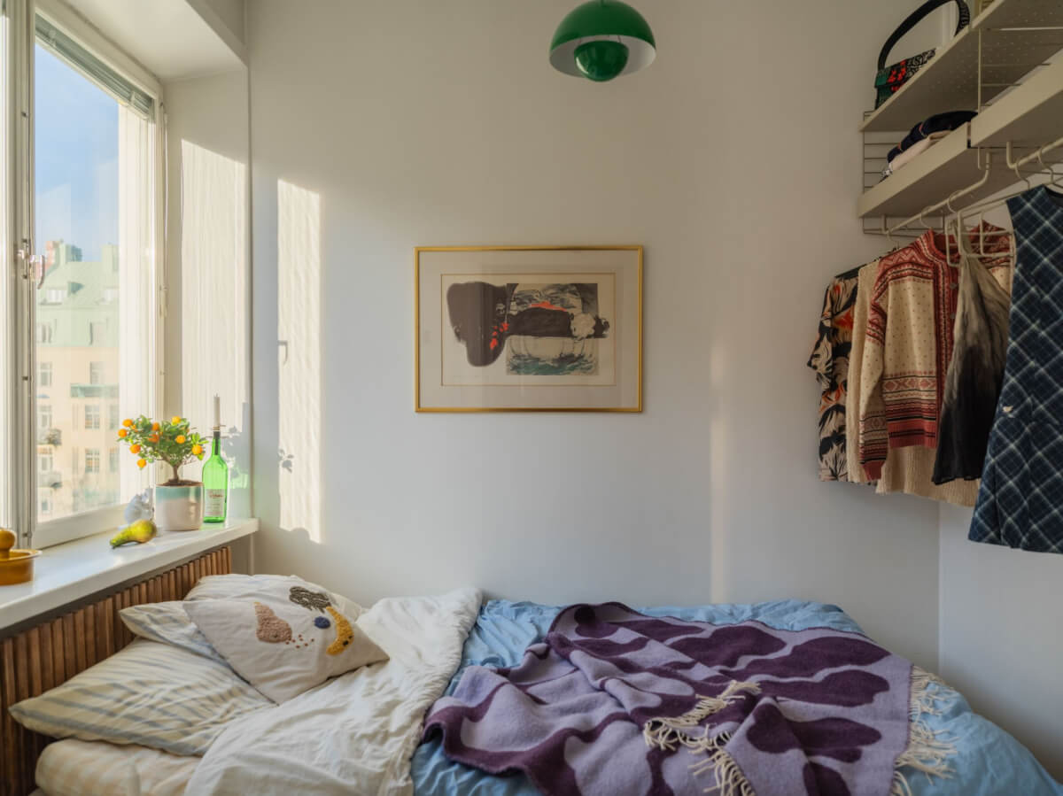 An Airy One-Bedroom Apartment with Art and A Yellow Kitchen 7 tiny bedroom with wall-mounted wardrobe solution