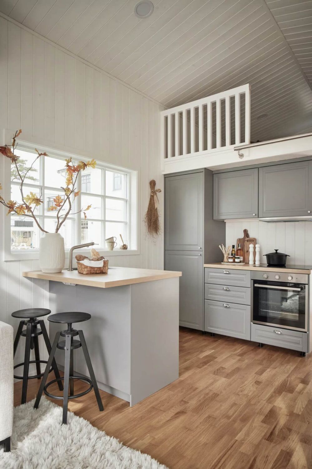 A Charming Tiny House in Sweden with a Private Terrace 9 tiny house kitchen gray cabinets island and bar seating
