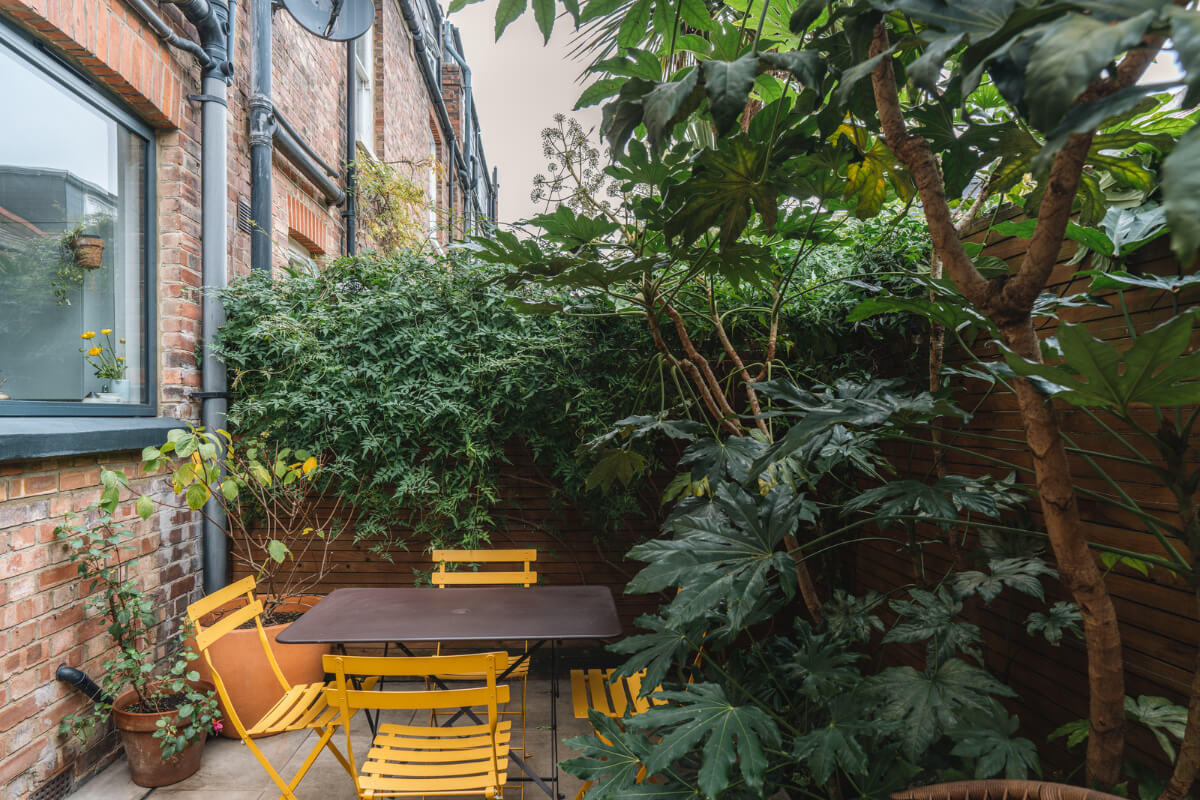 A Charming Light Edwardian House with a Tiny Garden 20 tiny lush garden yellow bistro seating