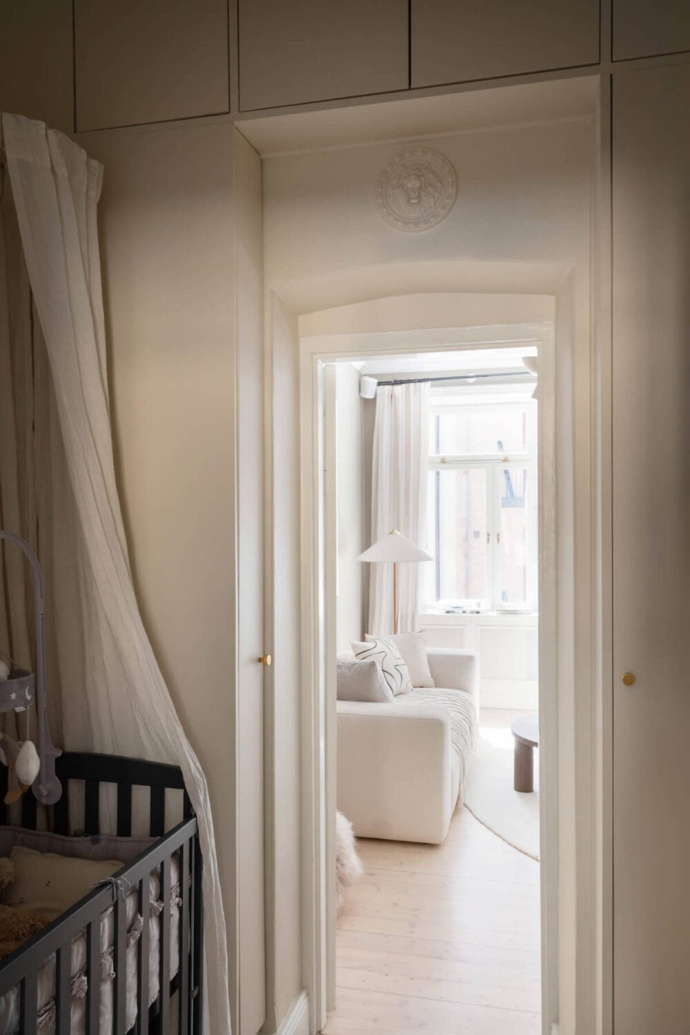 A Calm, Neutral Color Palette in a Classic Swedish Apartment 22 tiny nursery with cabinets around door