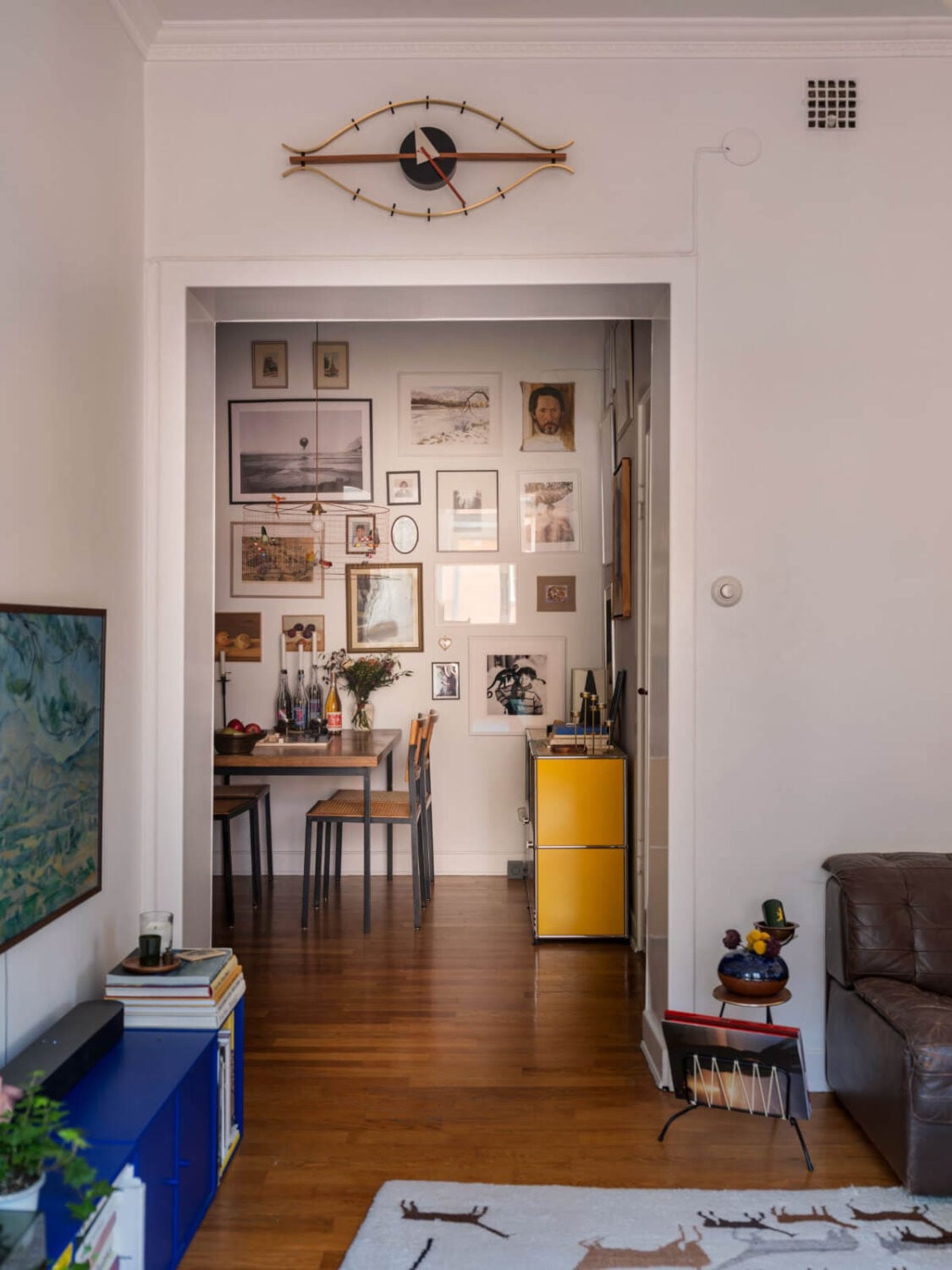 An Airy One-Bedroom Apartment with Art and A Yellow Kitchen 11 view into dining room