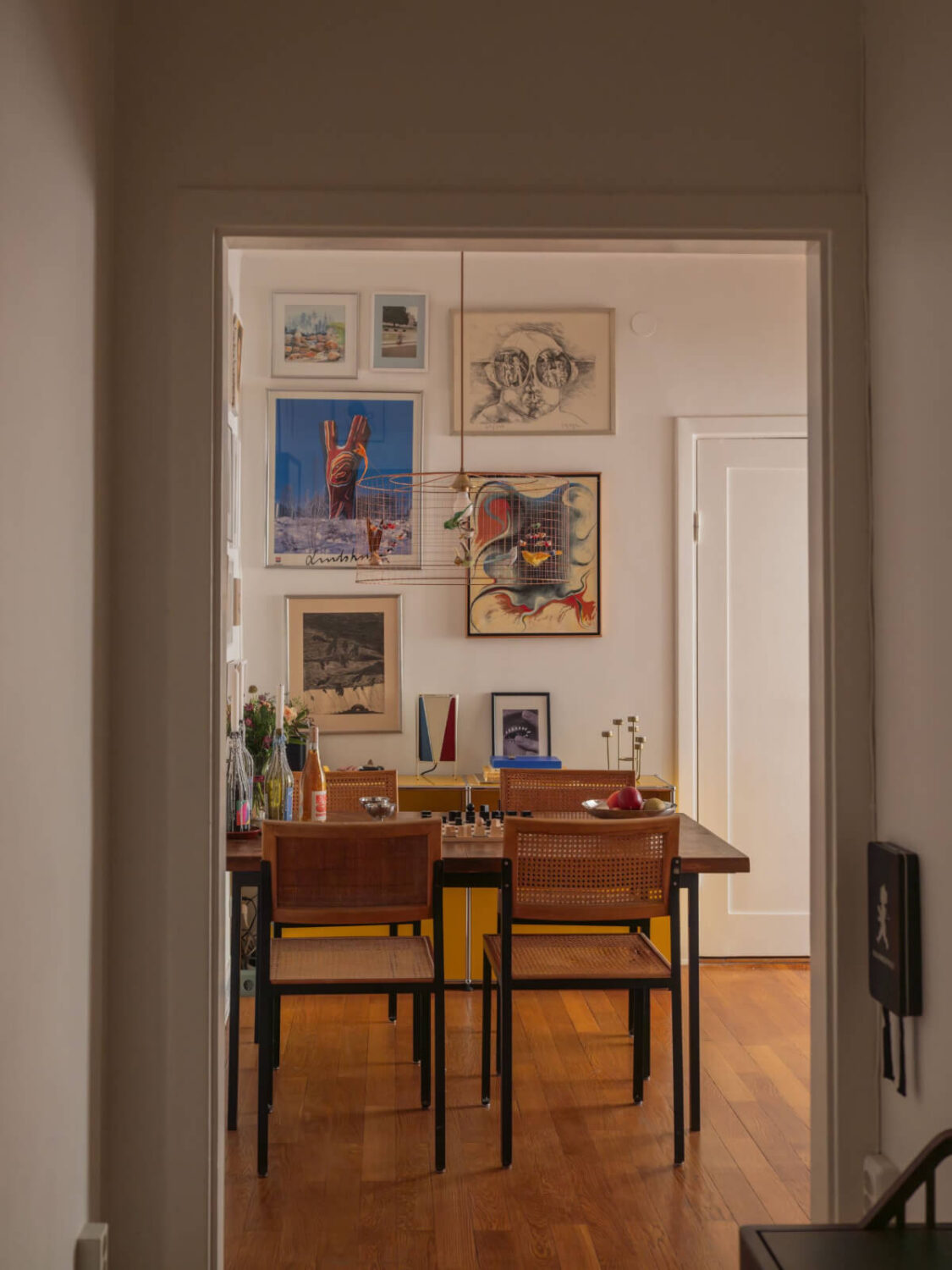 An Airy One-Bedroom Apartment with Art and A Yellow Kitchen 17 view into dining space