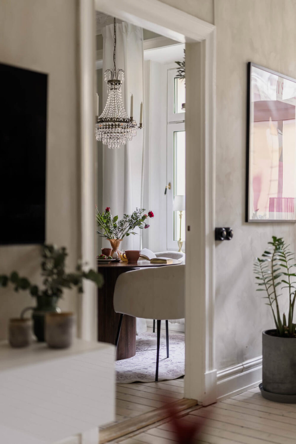 Limewash Wall and Period Features in a Swedish Apartment 7 view into kitchen with large chandelier
