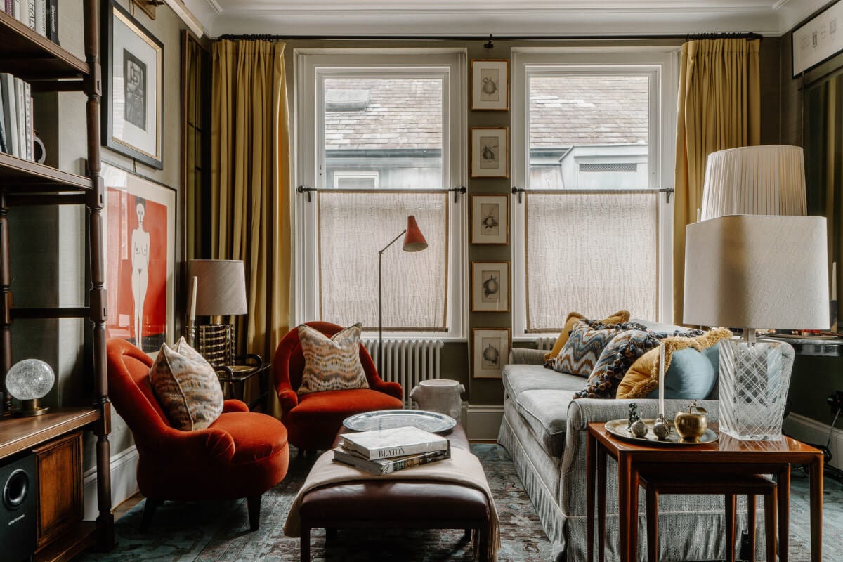 A Cozy Art-Filled Attic Apartment in London 2 warm living room with art and ochre yellow curtains