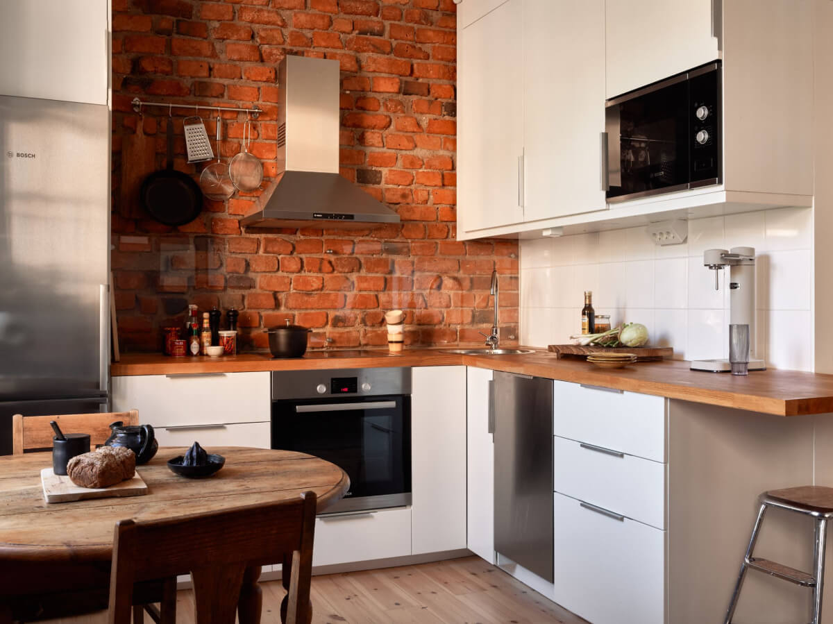 A Studio Apartment with Smart Storage Ideas and Exposed Brick 9 white cabinets exposed brick wall studio apartment