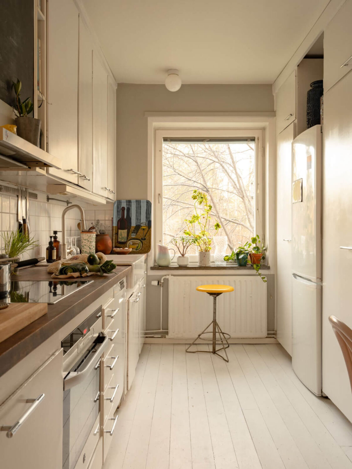 A Charming Midcentury Apartment with a Reading Room 12 white kitchen