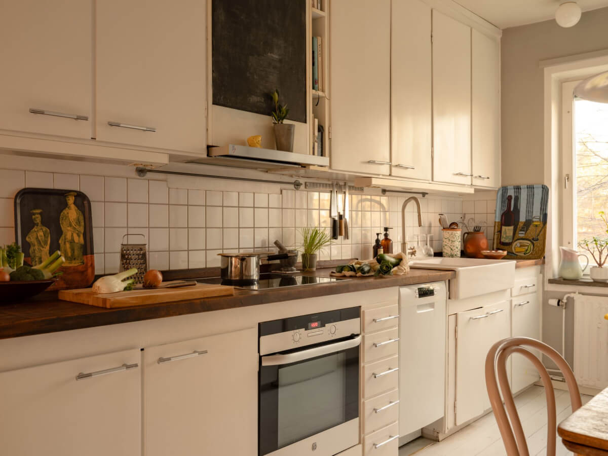 A Charming Midcentury Apartment with a Reading Room 11 white kitchen with wooden worktop