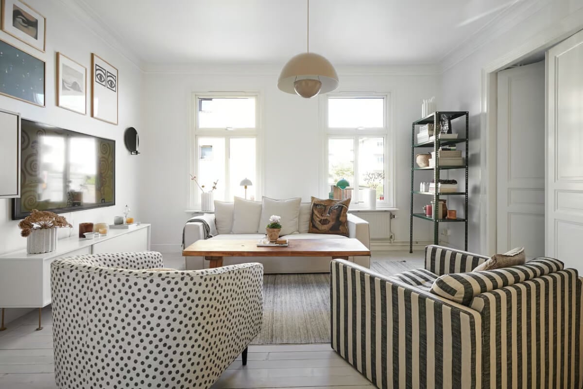A Bright Turn-of-the-Century Apartment in Sweden 1 white living room with striped and dotted armchair