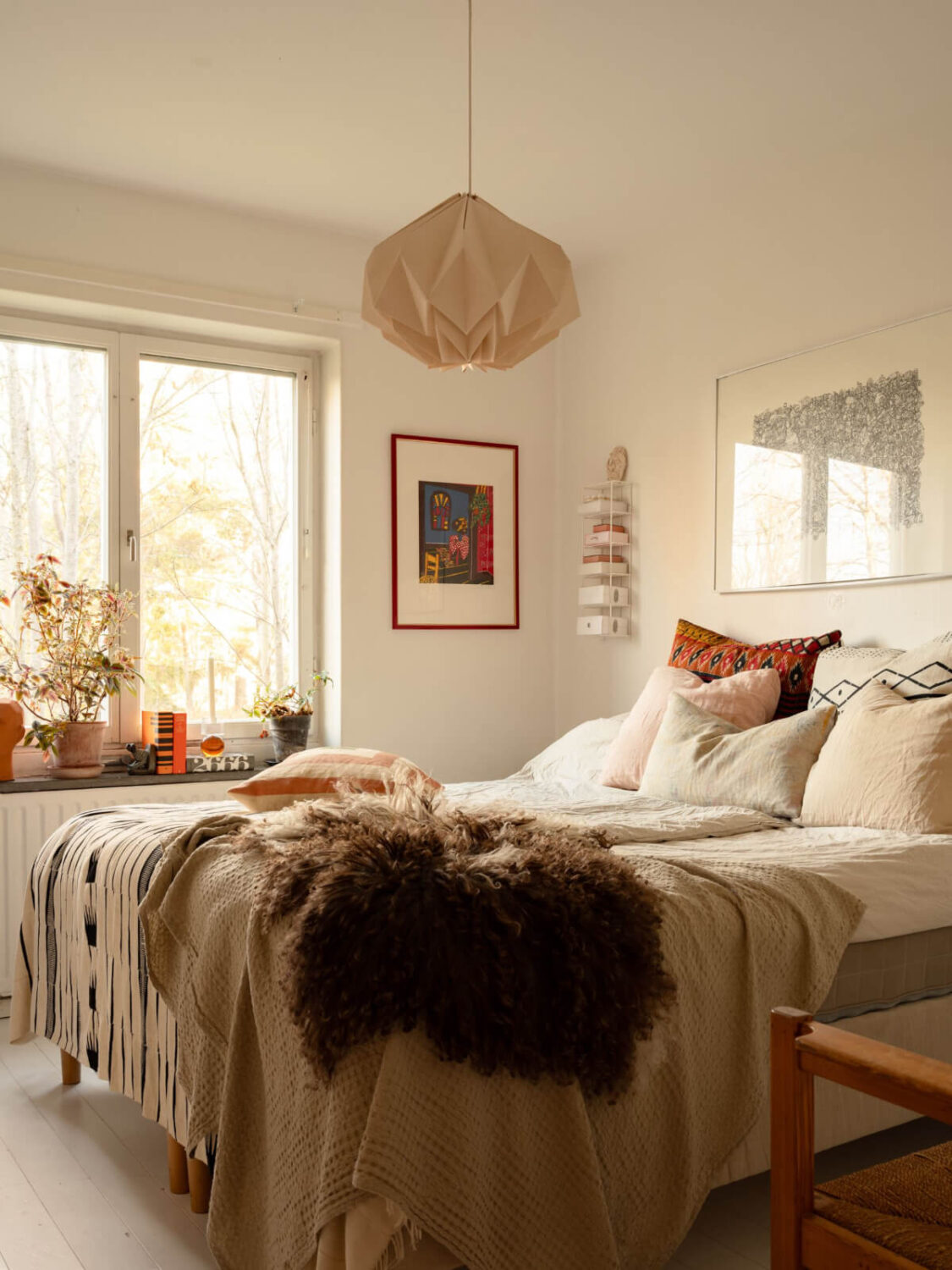 A Charming Midcentury Apartment with a Reading Room 24 white master bedroom with layered textiles