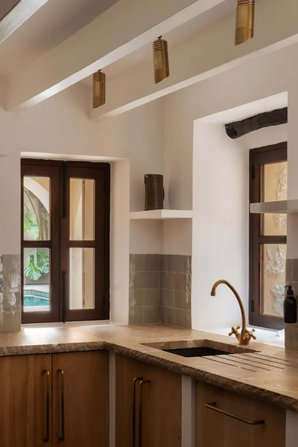Old-World Craftsmanship and Contemporary Elegance in a Mallorcan Townhouse 4 wooden kitchen green backsplash tiles brass fittings