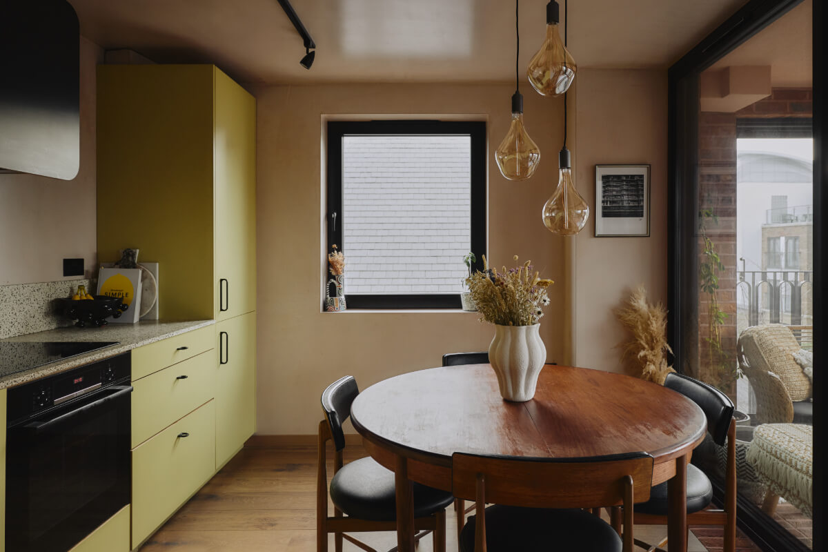 An Elegant Apartment with Plaster Walls and a Winter Garden 7 yellow-green kitchen and wooden round table