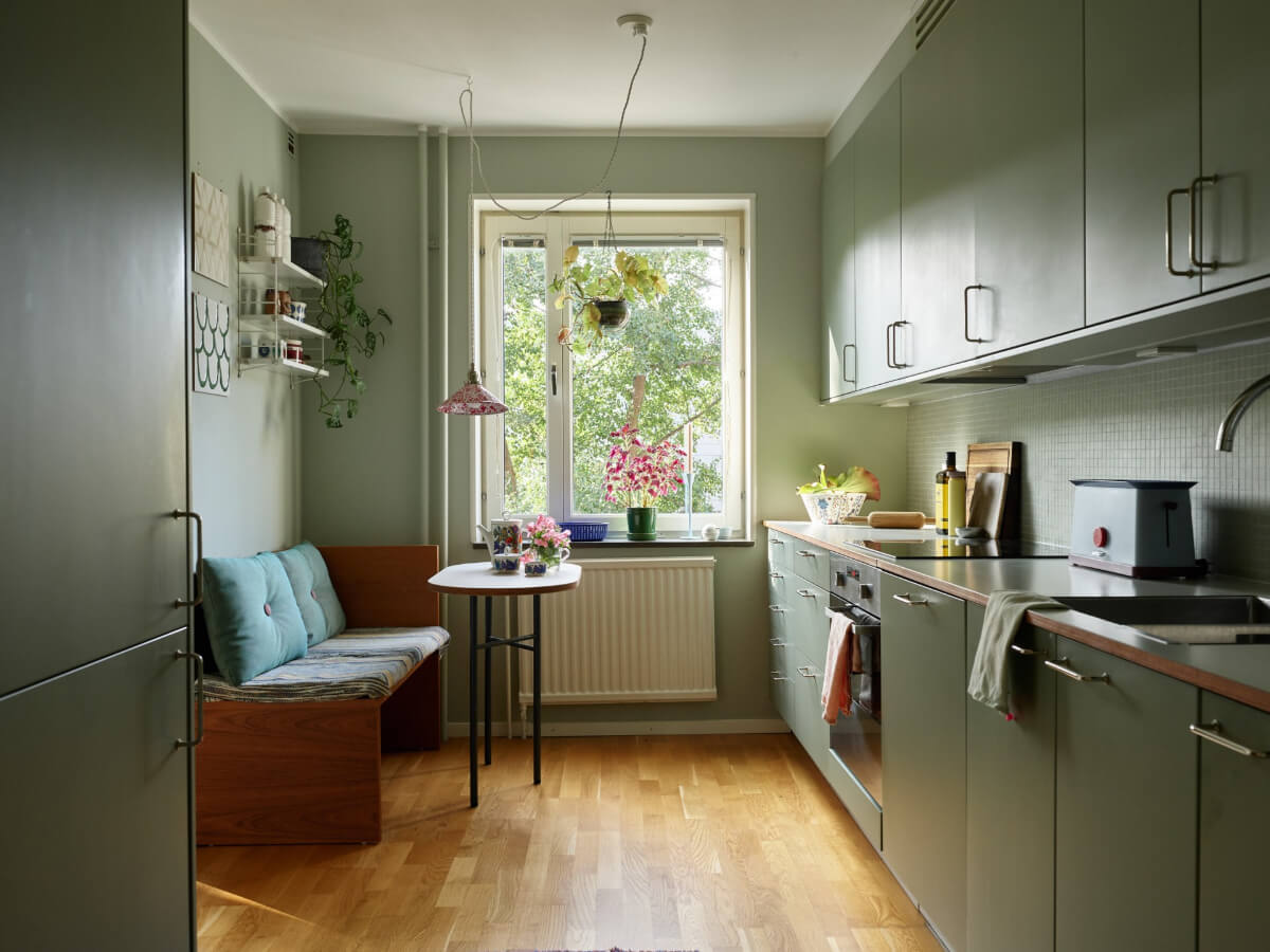 A Lovely Color Palette in a Midcentury Apartment in Sweden 16 all-green kitchen parquet floor breakfast table with bench