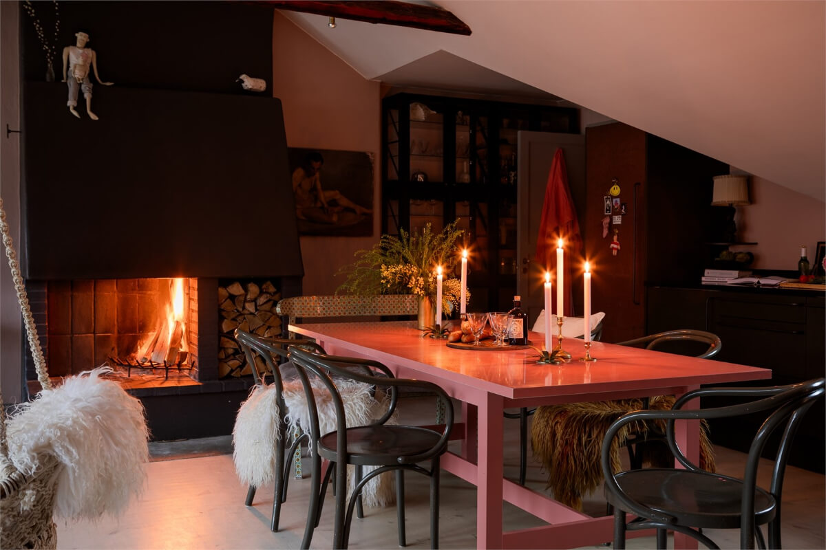 A Colorful Family Attic Apartment in Stockholm 17 attic living room at night fireplace pink dining table