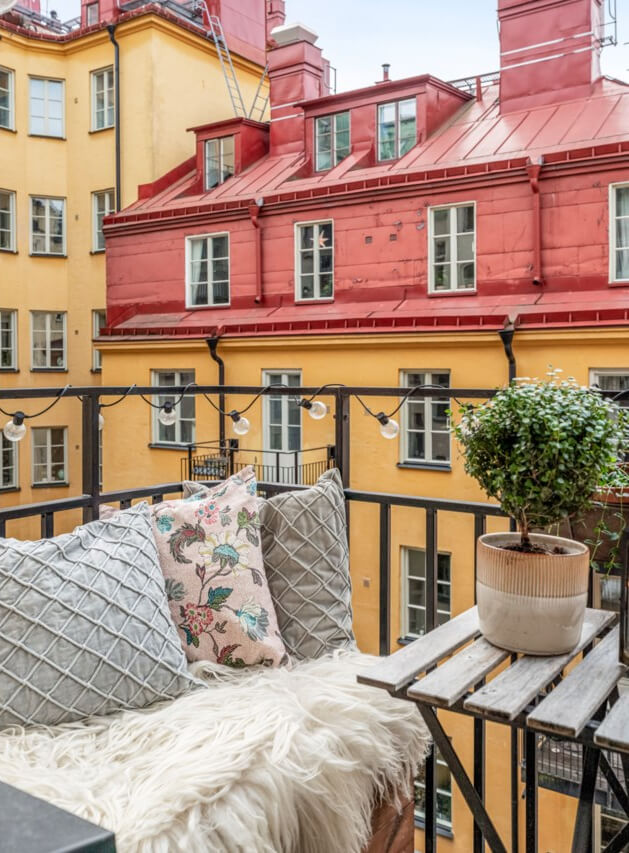 A Small Light-Filled Apartment with a Pink Bedroom 5 balcony small table with bench