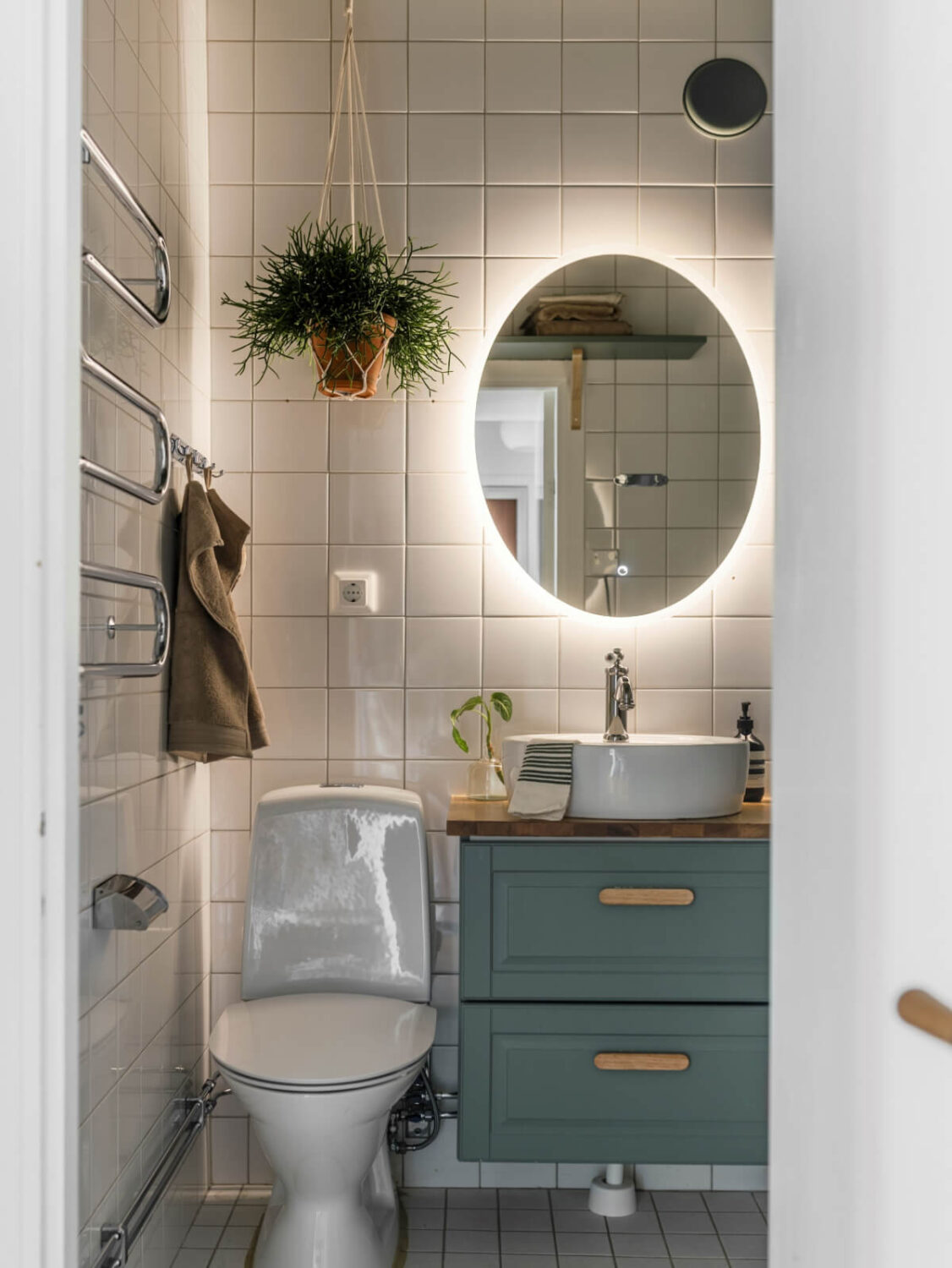 Cozy Plant-Filled Interiors in a 1940s Apartment 20 bathroom blue-green cabinet