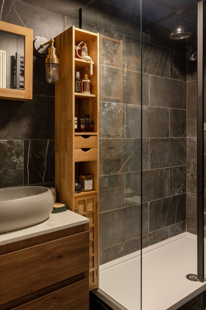 A Muted Color Palette in a Charming Ground Floor Apartment 17 bathroom dark tiles wooden vanity dresser
