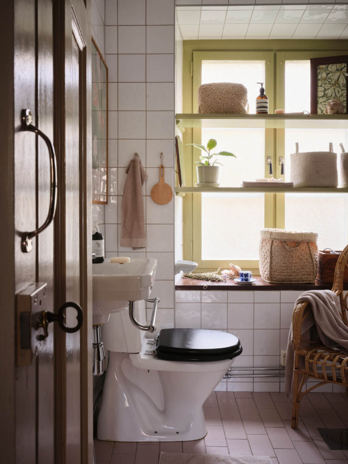 A Charming Vintage Apartment with Historic Wallpapers in Stockholm 16 bathroom with green window and shelves