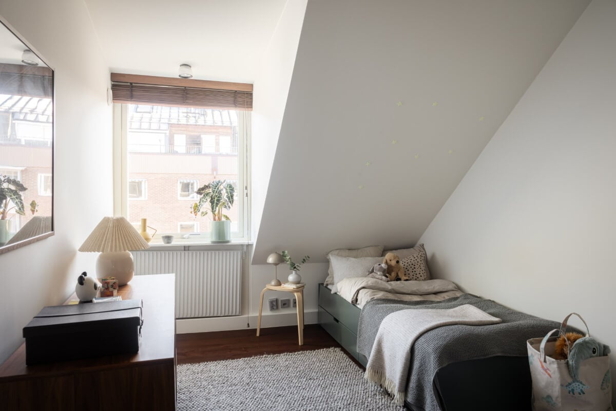 A Light Penthouse Apartment with Built-In Bookshelves 21 bedroom slanted ceiling gray textiles