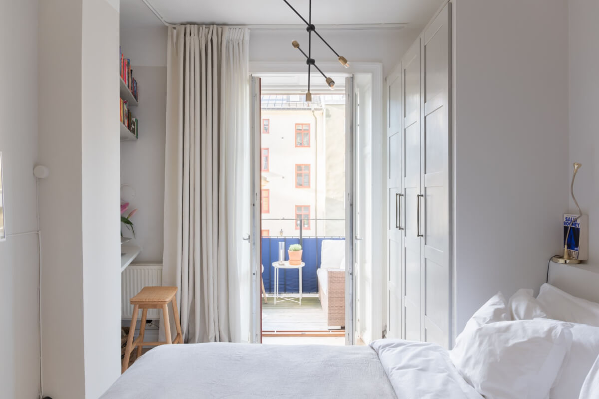 A Small Apartment Decorated in a Light Gray & White Color Palette 14 bedroom with desk and large wardrobes