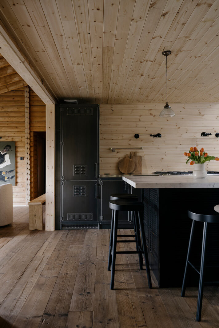 A Cozy and Contemporary Take on a Traditional Log House 7 black kitchen with marble topped island