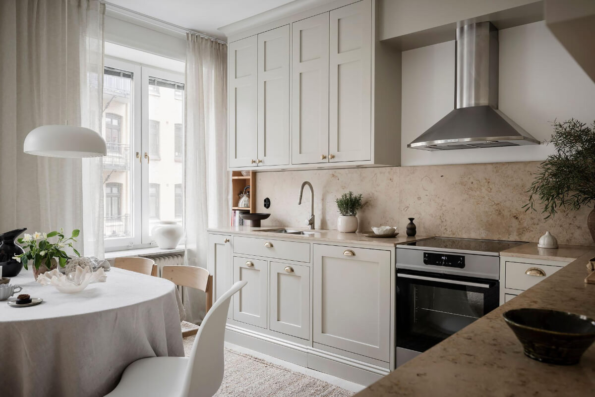 A Light Corner Apartment with an Open Flowing Floor Plan 11 classic light gray kitchen brass knobs