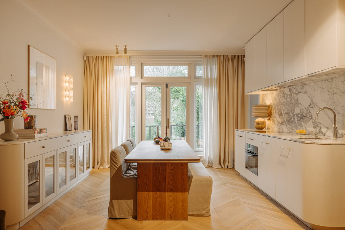 A Luxurious Apartment in Amsterdam with a Lovely Master Suite 4 curved white kitchen large wooden dining table