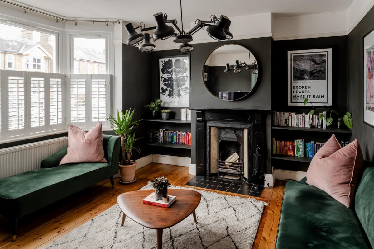 A Contrasting Color Palette in a Renovated Terrace House 1 dark gray living room bay window green velvet sofas and fireplace