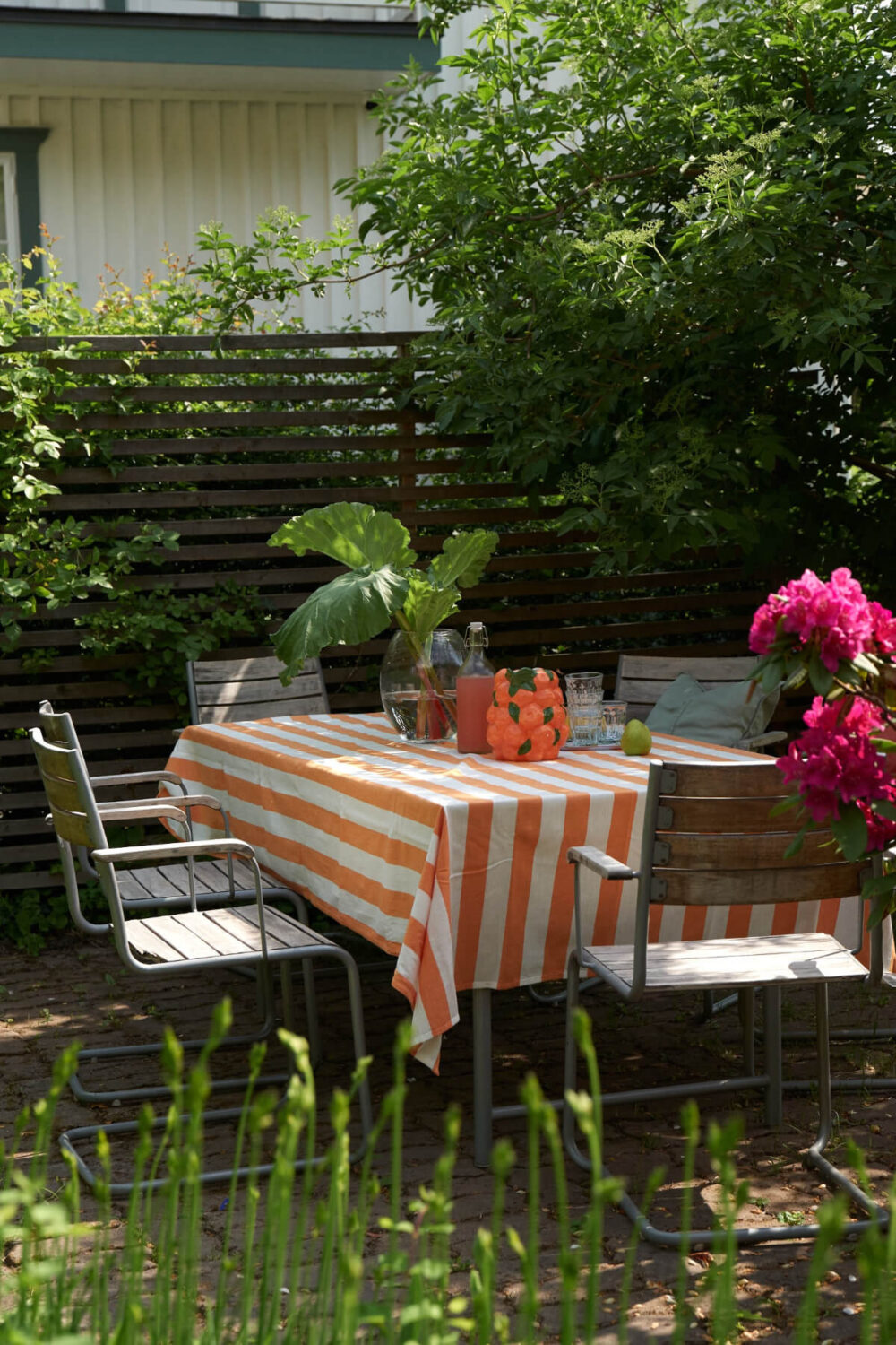 Colorful Decor in a Charming Family Duplex Apartment in Stockholm 35 garden seating orange striped tablecloth