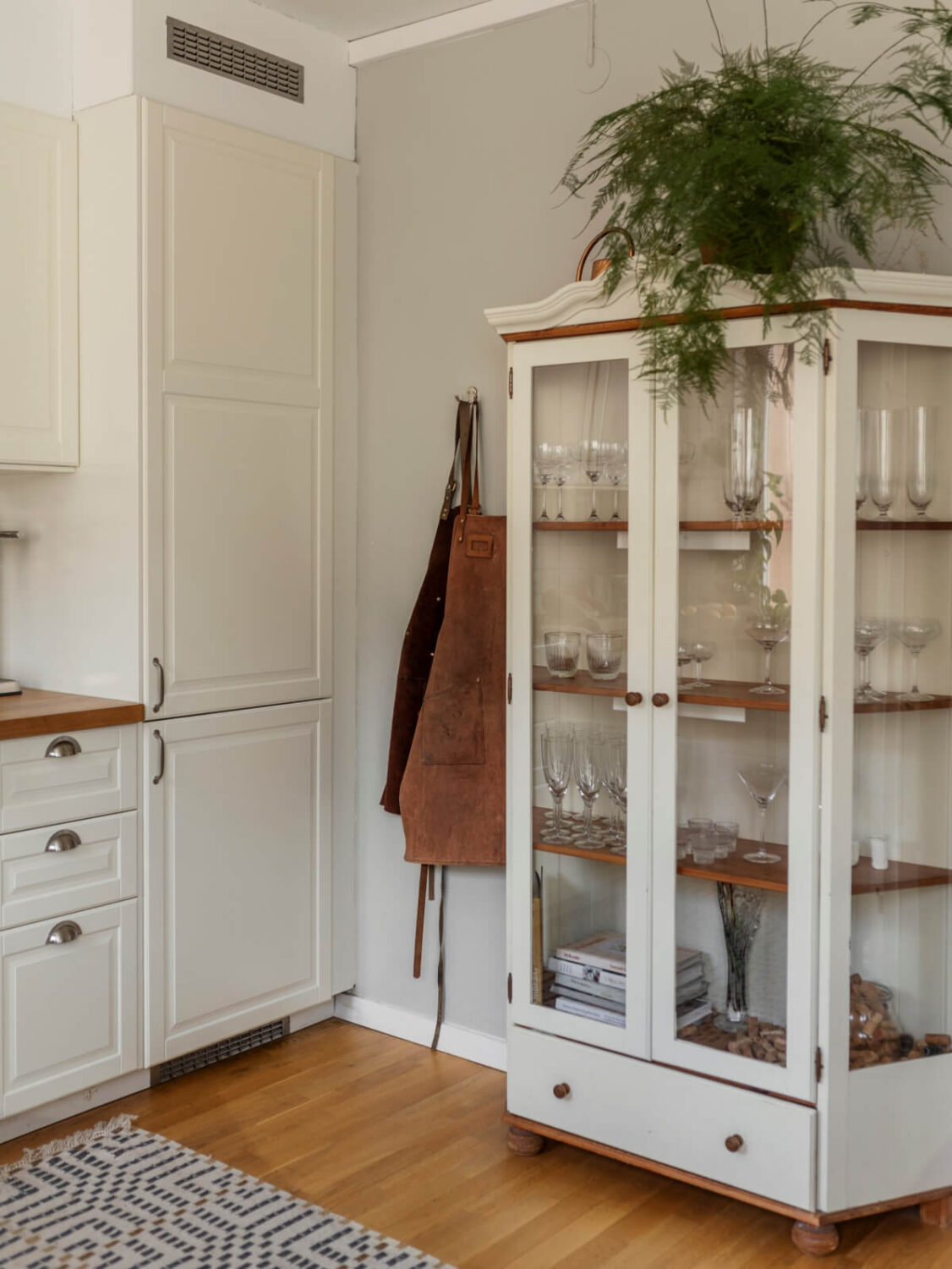 Cozy Plant-Filled Interiors in a 1940s Apartment 12 glass cabinet kitchen