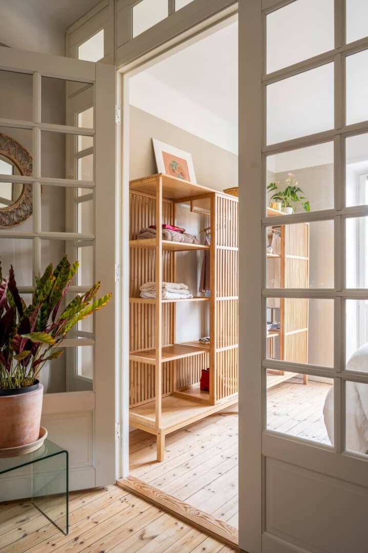 A Light Swedish Apartment with a Green Living Room 20 glass doors to bedroom with half open wardrobes