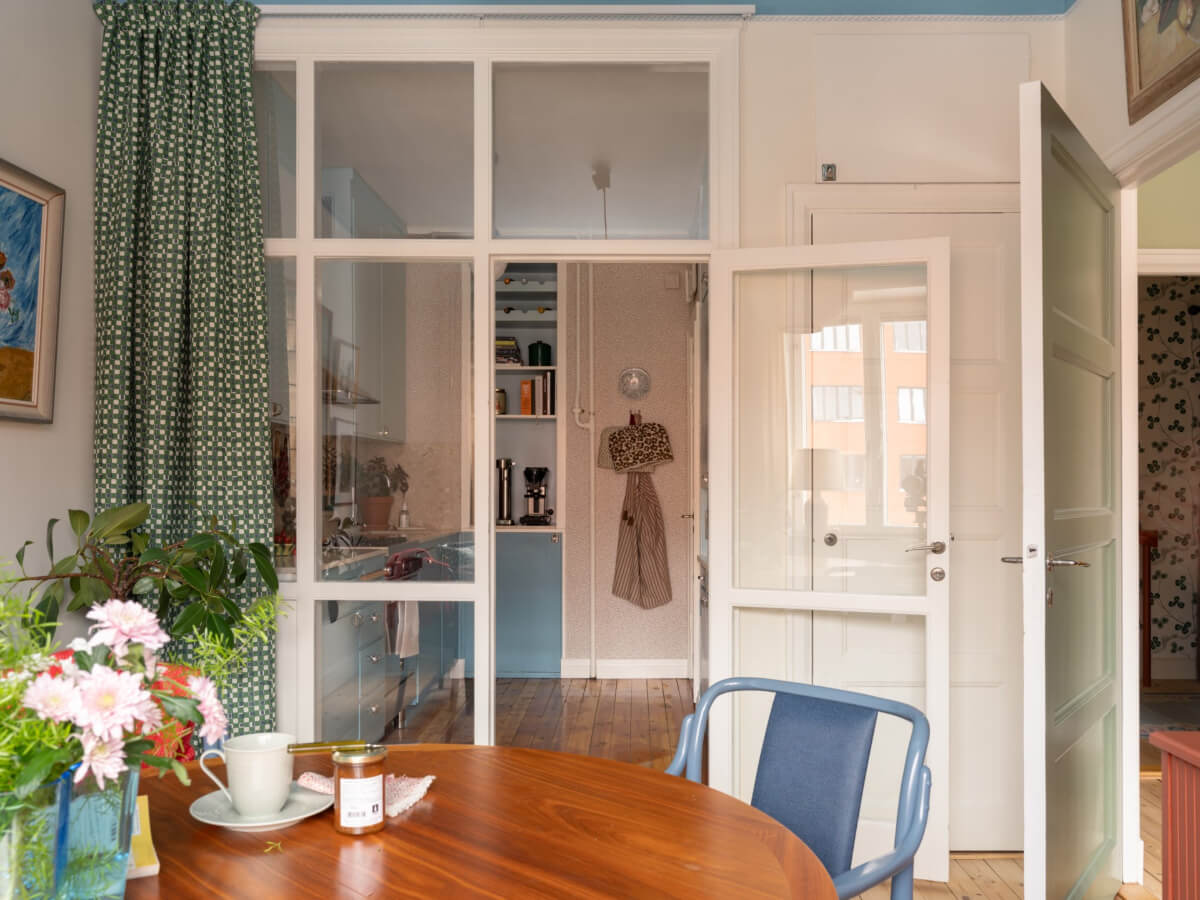 A Beautiful Well-Preserved 1930s Apartment with a Blue Kitchen 8 glass partition dining room kitchen with green curtain