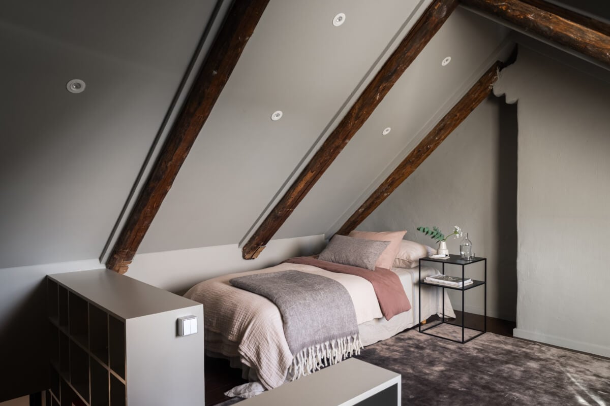 A Light Penthouse Apartment with Built-In Bookshelves 27 gray attic bedroom wooden beams