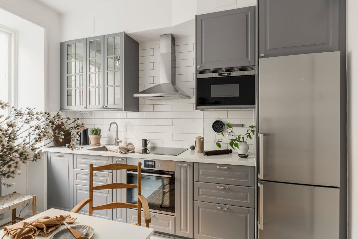 A Light Swedish Studio in an Early 20th Century Building 14 gray kitchen cabinets white tiles