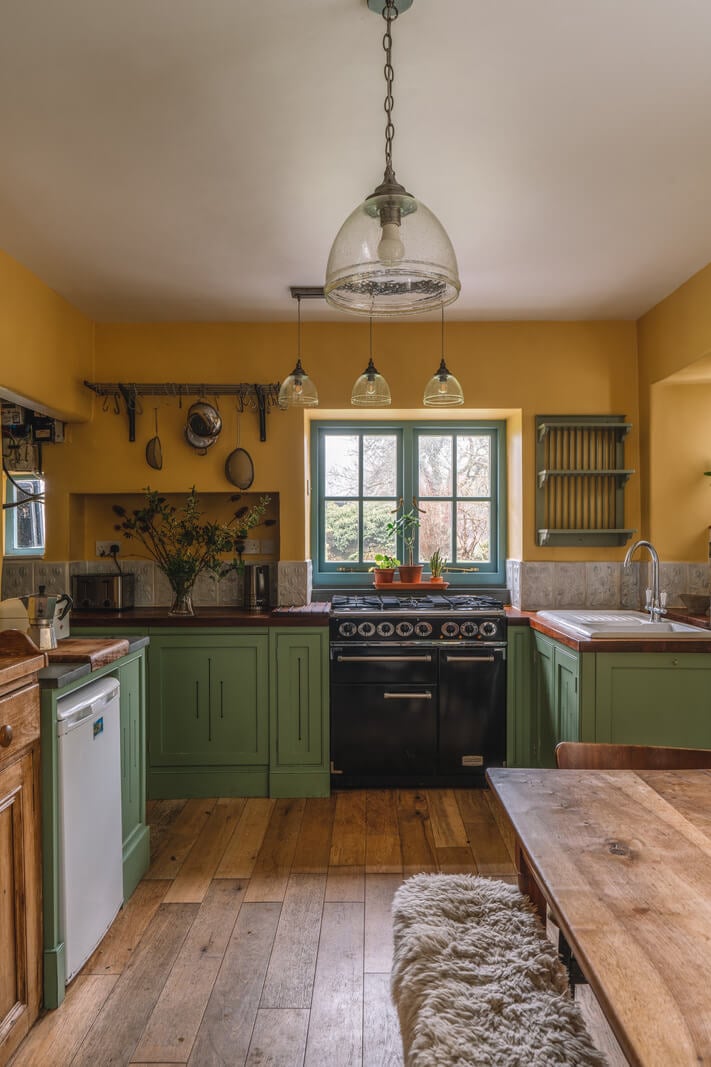 A Colorful 19th-Century Cottage in the Lake District 4 green and ochre yellow cottage kitchen wooden floor