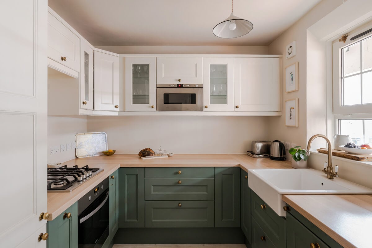 A Calm & Stylish Color Palette in a Small London Apartment 8 green and white kitchen with wooden countertop