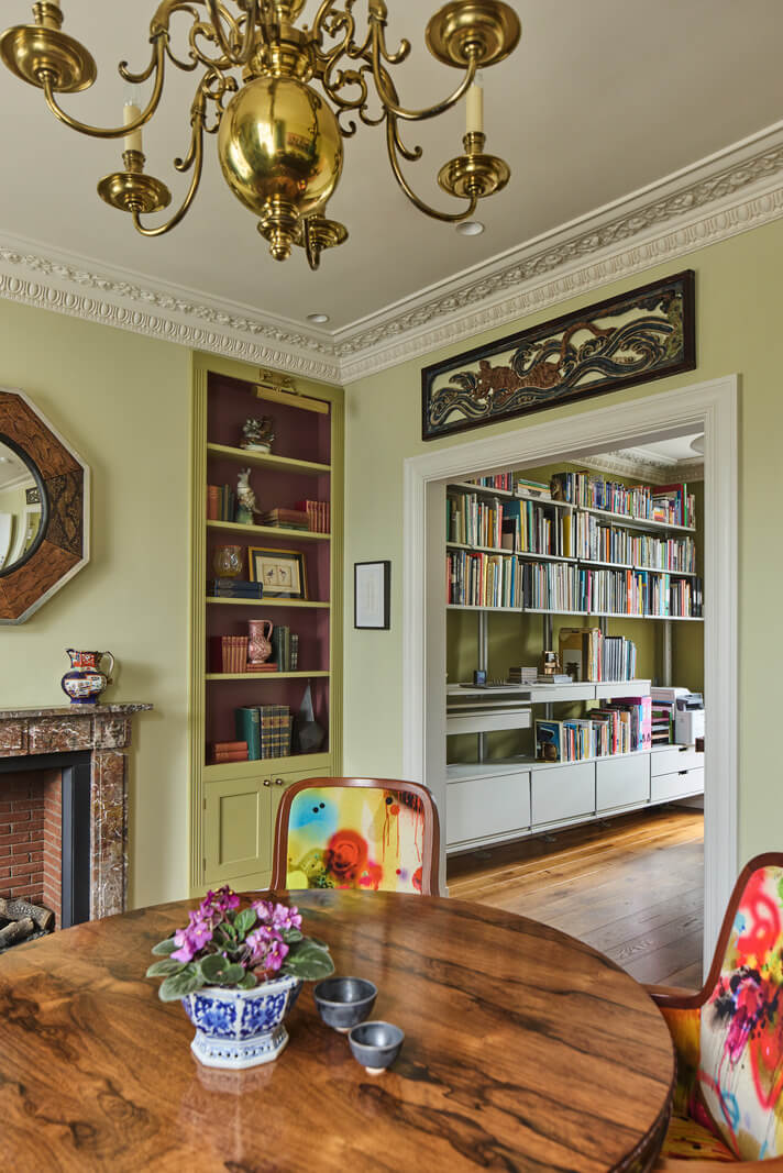 A Renovated Early Victorian Townhouse Decorated in Green Tones 9 green dining room fireplace bookshelves