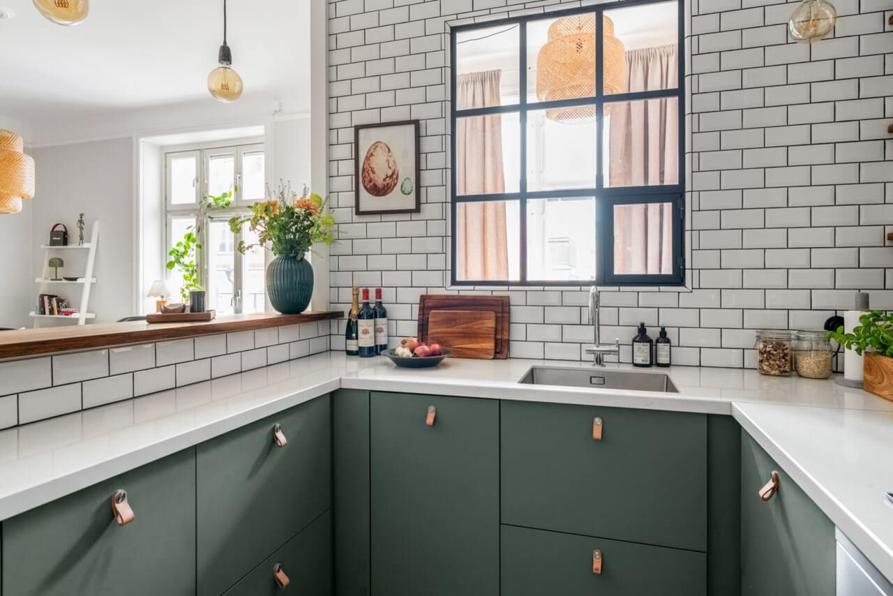 A Small Light-Filled Apartment with a Pink Bedroom 11 green kitchen white subway tiles