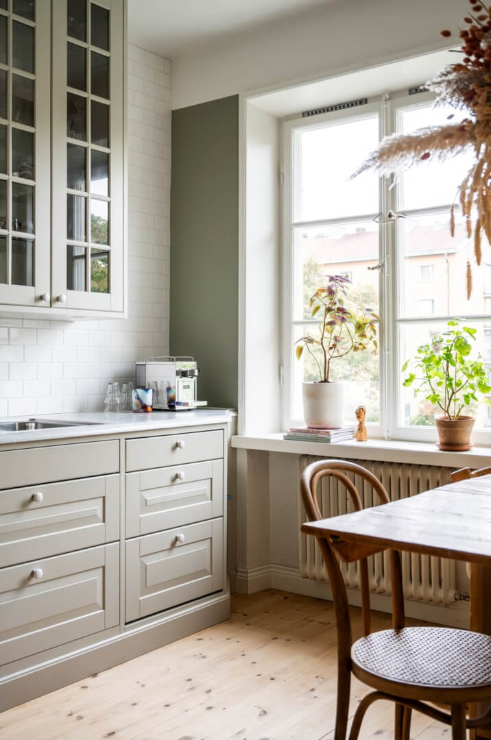 A Light Swedish Apartment with a Green Living Room 9 green kitchen with white tiles