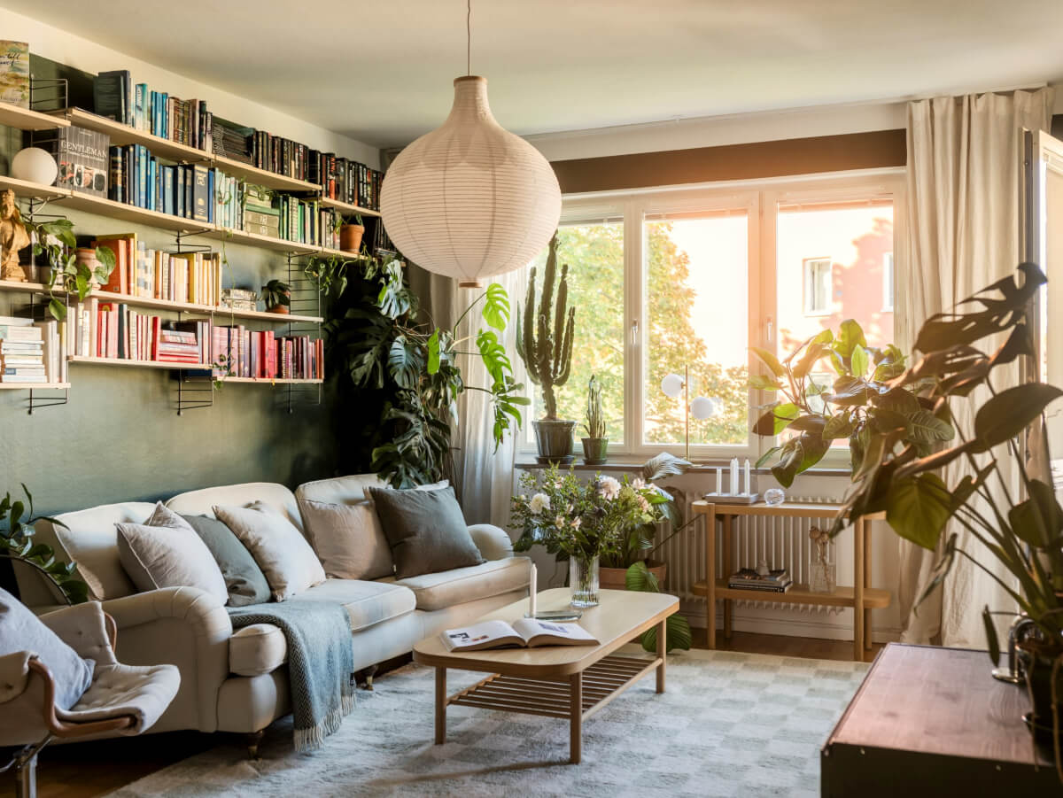 Cozy Plant-Filled Interiors in a 1940s Apartment 1 green plant-filled living room with bookshelves