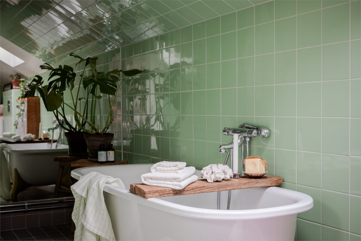 A Colorful Family Attic Apartment in Stockholm 31 green tiles large mirror freestanding bath